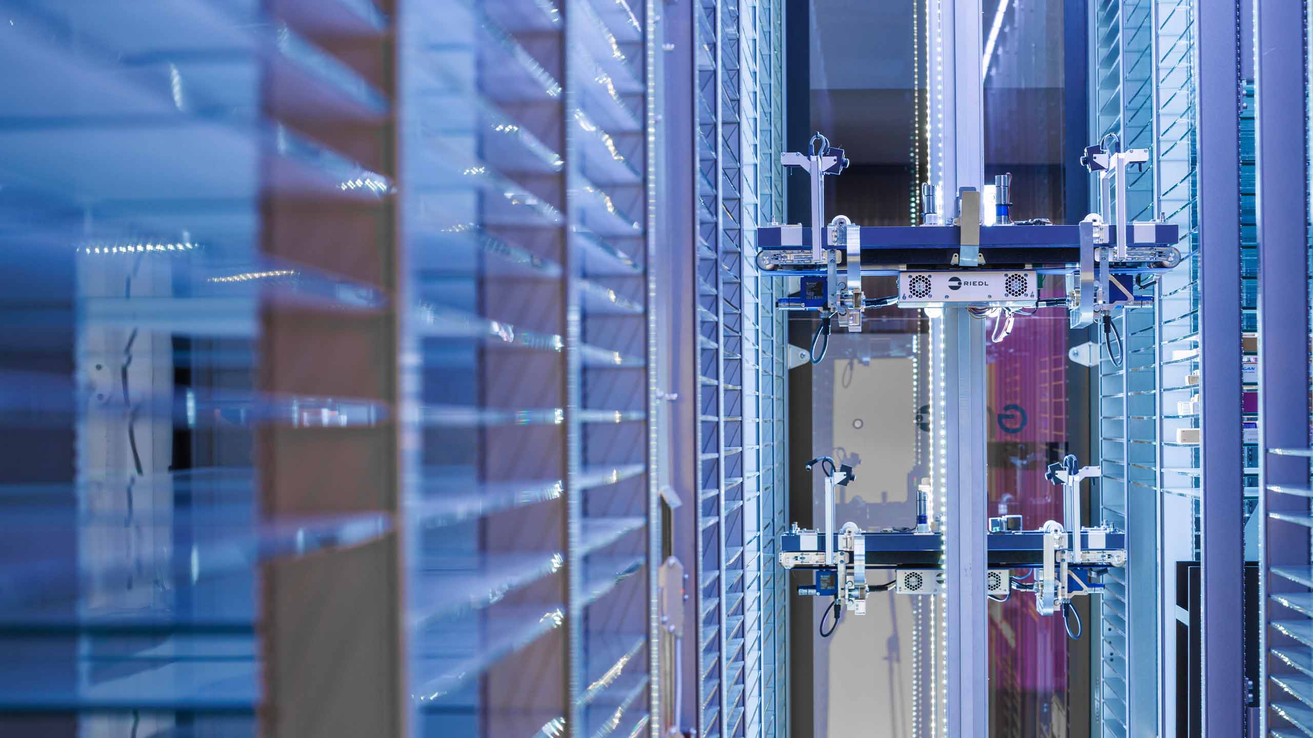 Pinza robotizzata RIEDL all'interno del magazzino illuminata di blu