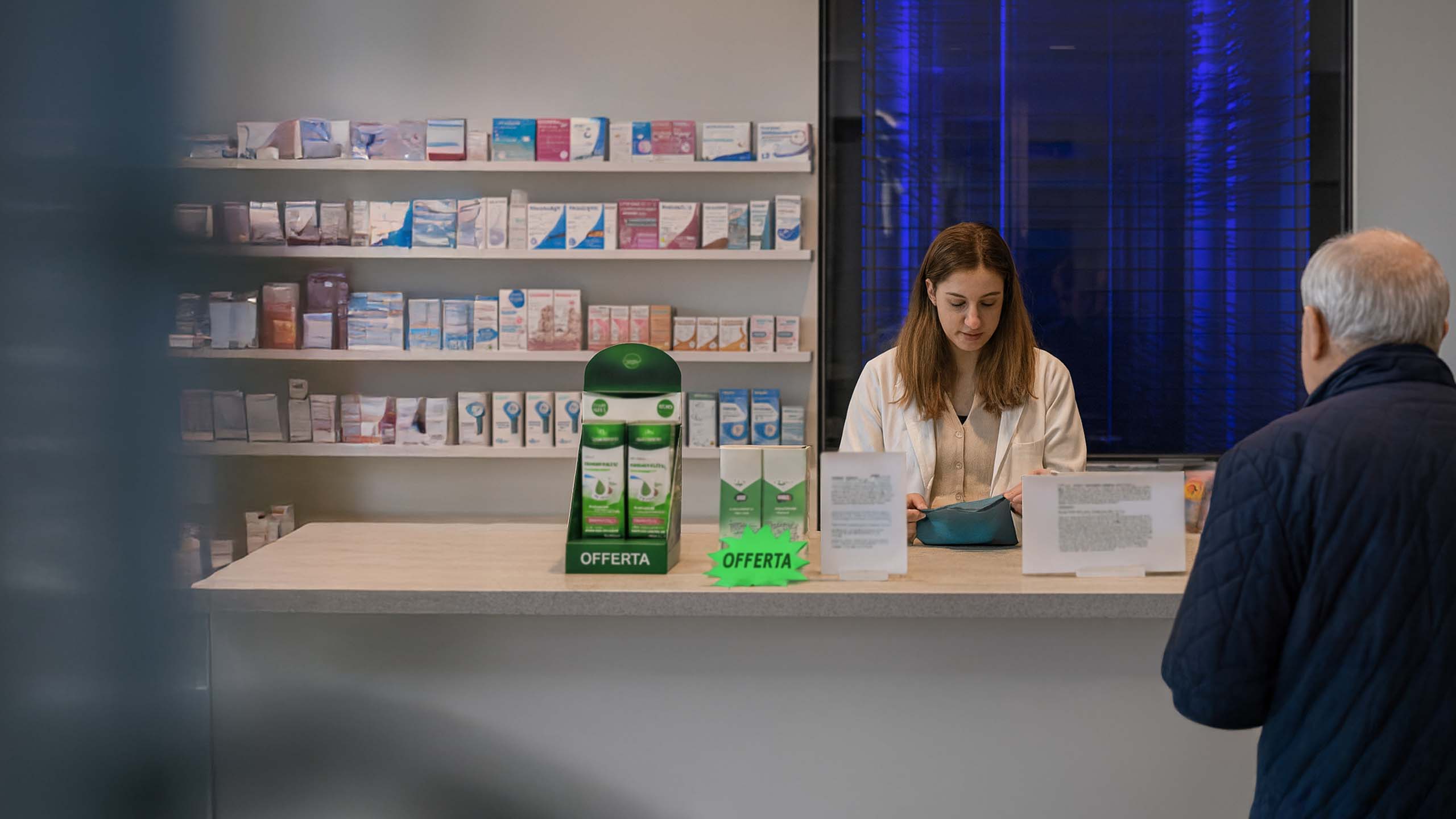 Farmacista al banco che serve il cliente in attesa