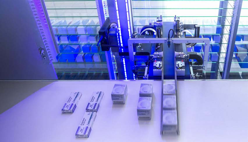 Pinza RIEDL che preleva i prodotti dal nastro all'interno del magazzino robotizzato